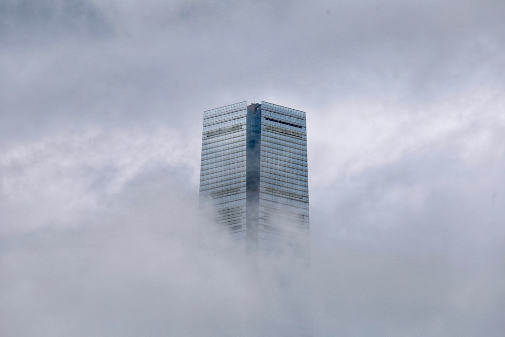 un alto edificio in mezzo a un cielo pieno di nuvole