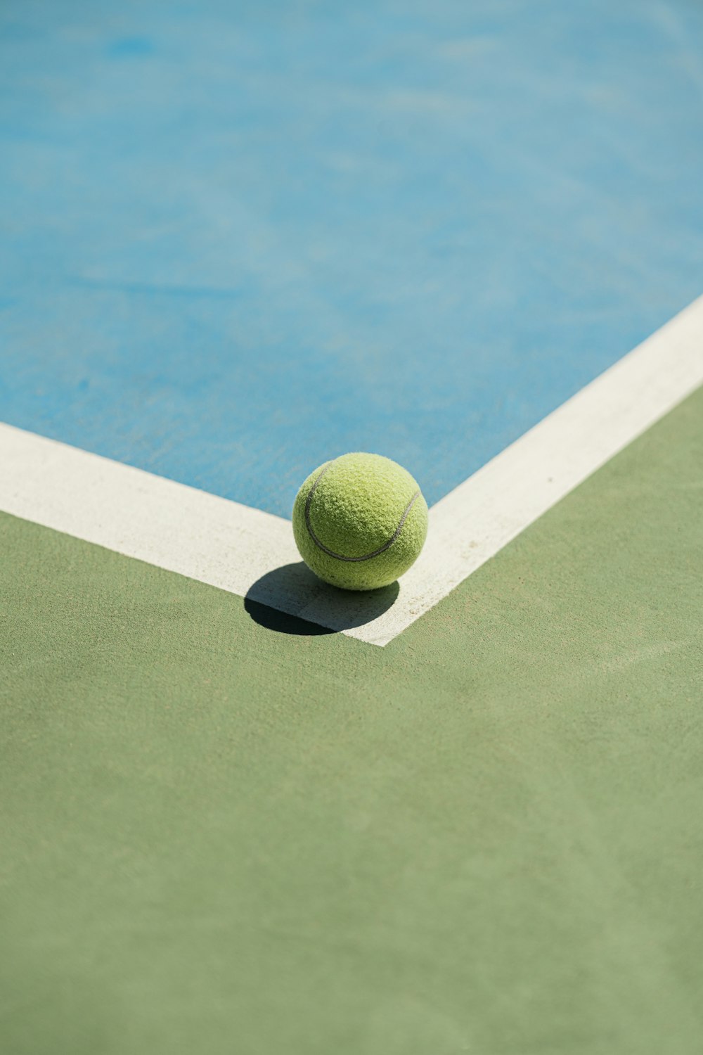 a tennis ball sitting on the edge of a tennis court