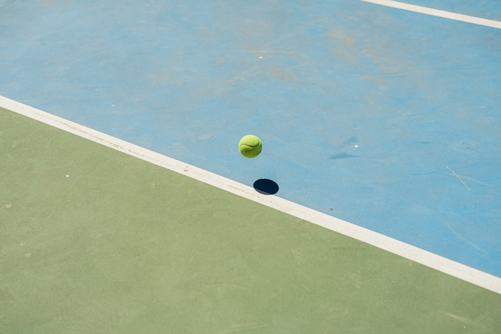 a tennis ball on a blue and green tennis court