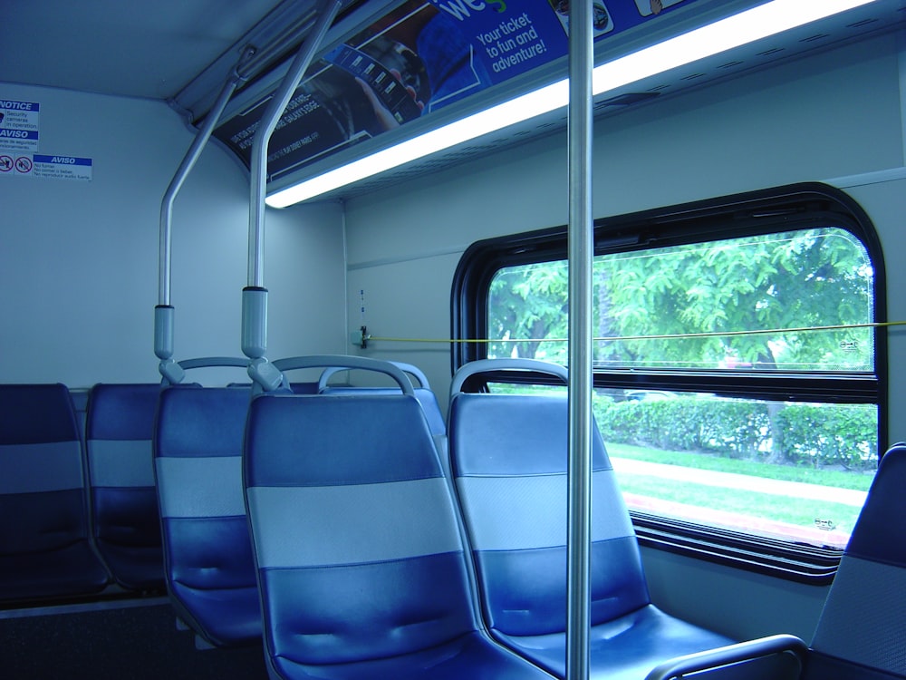 a row of blue seats sitting next to a window