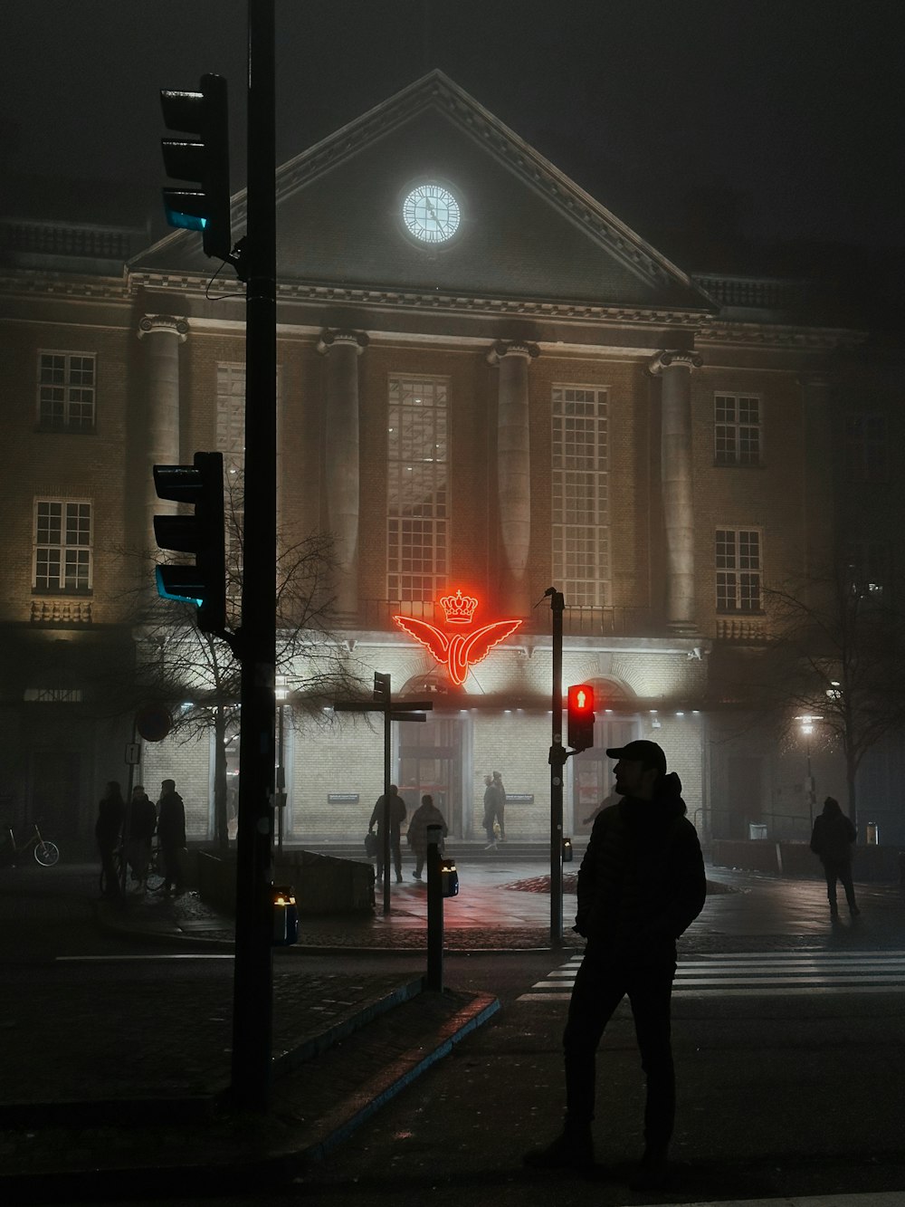 eine Person, die nachts vor einem Gebäude steht