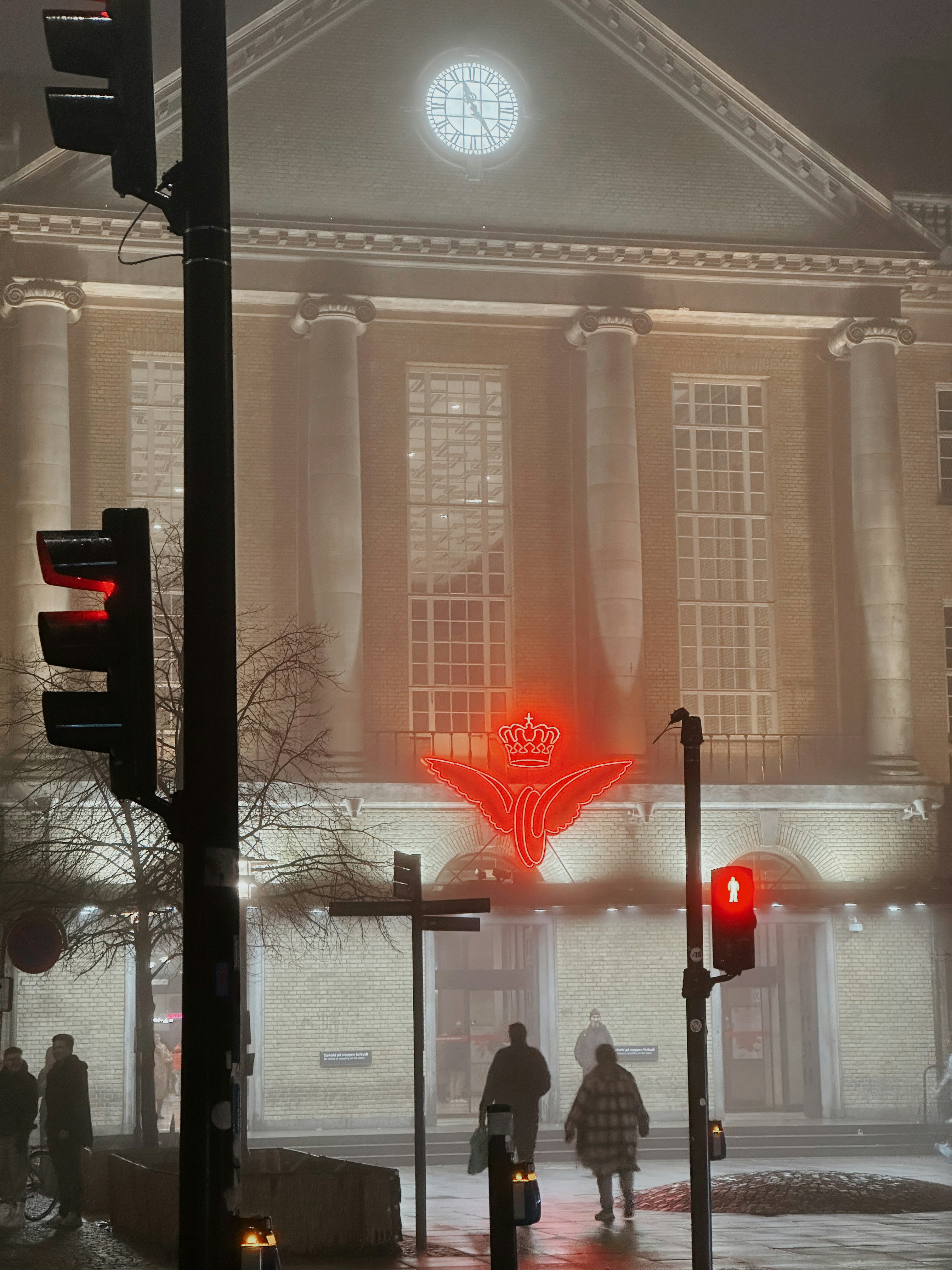 a red traffic light sitting in front of a tall building