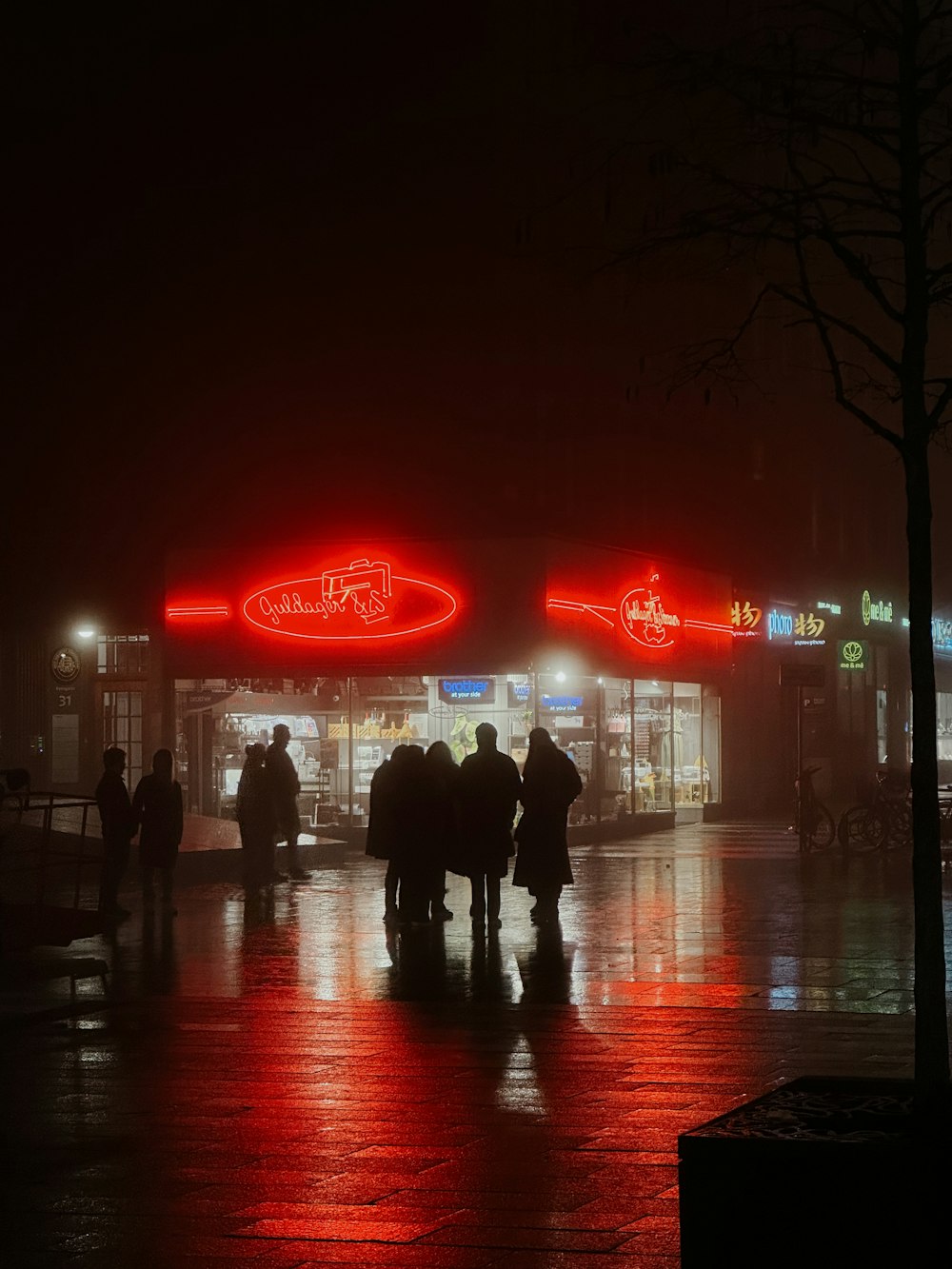 a group of people standing outside of a store at night