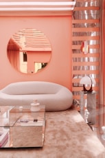 a living room with a round mirror on the wall