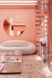 a living room with a round mirror on the wall