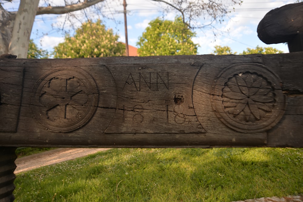 a close up of a wooden bench with carvings on it