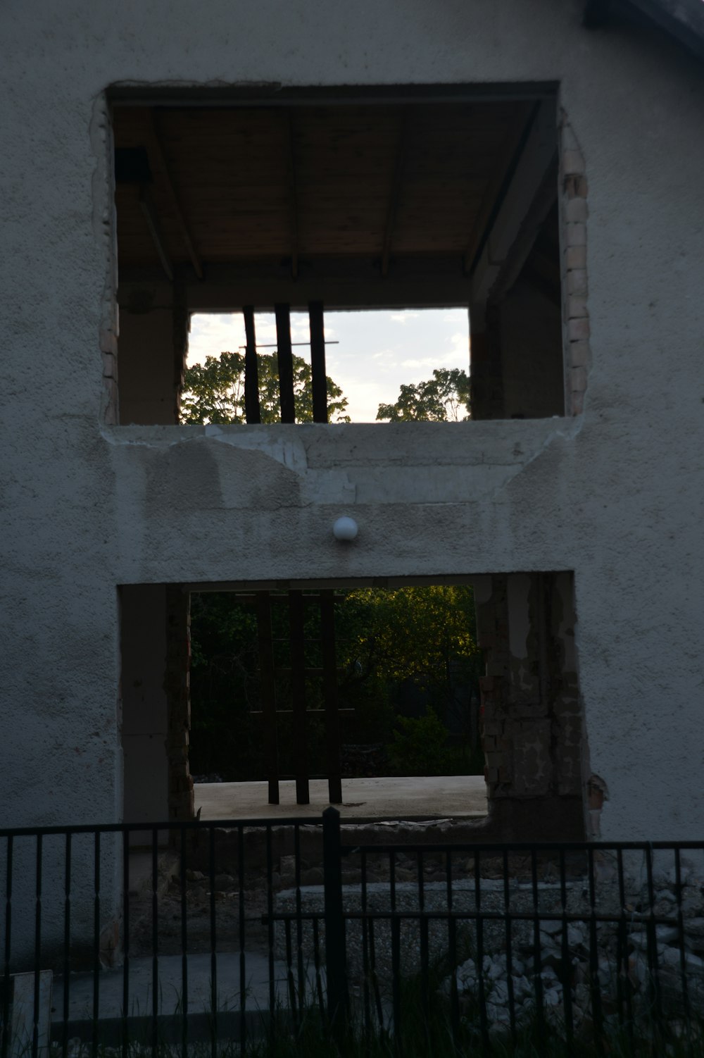 an open window in a white building with a black fence