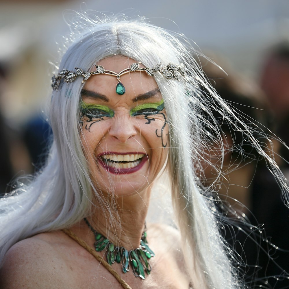 a woman with white hair and green makeup