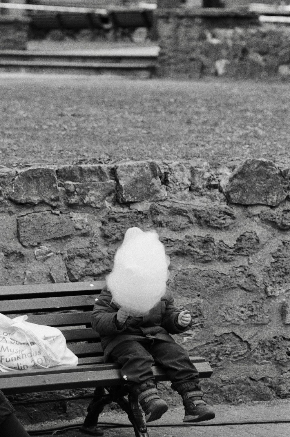 a woman sitting on top of a bench next to a child