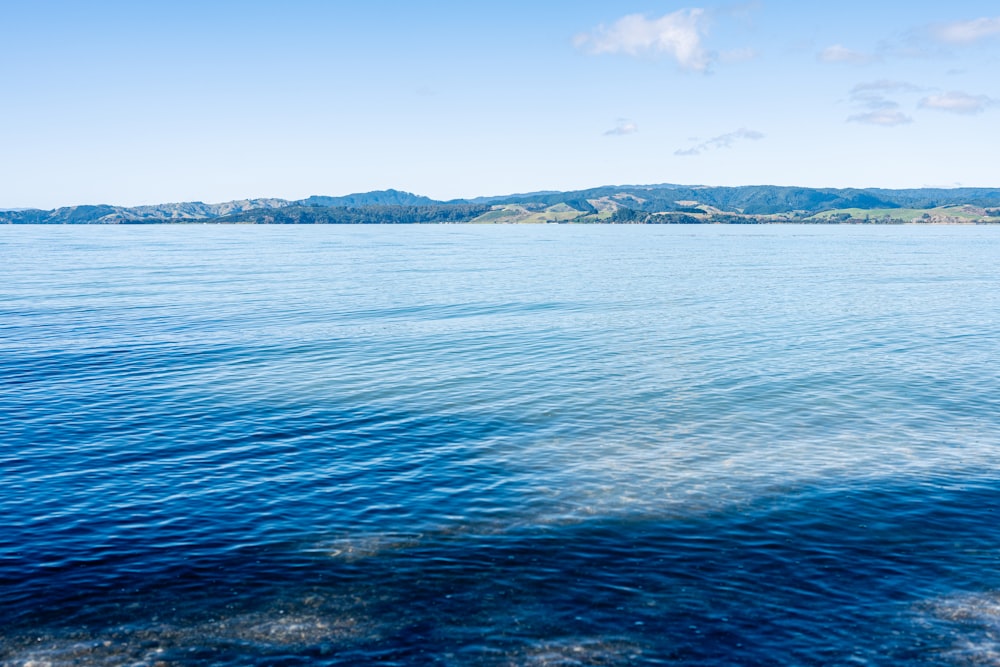 a large body of water with mountains in the background