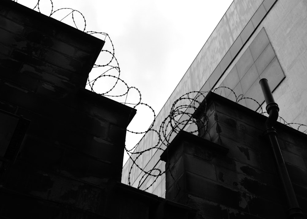 a black and white photo of a building with barbed wire