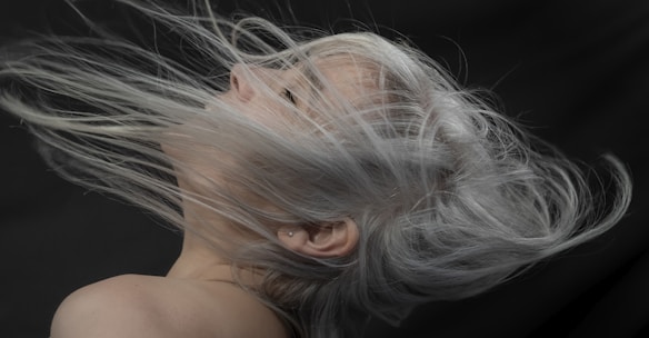 a woman with grey hair blowing in the wind