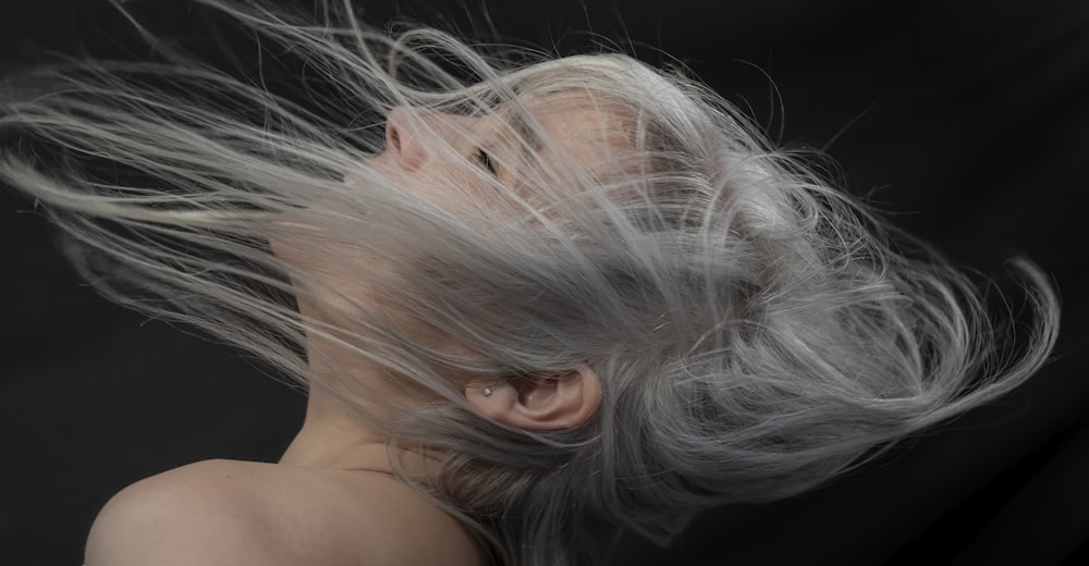 a woman with grey hair blowing in the wind