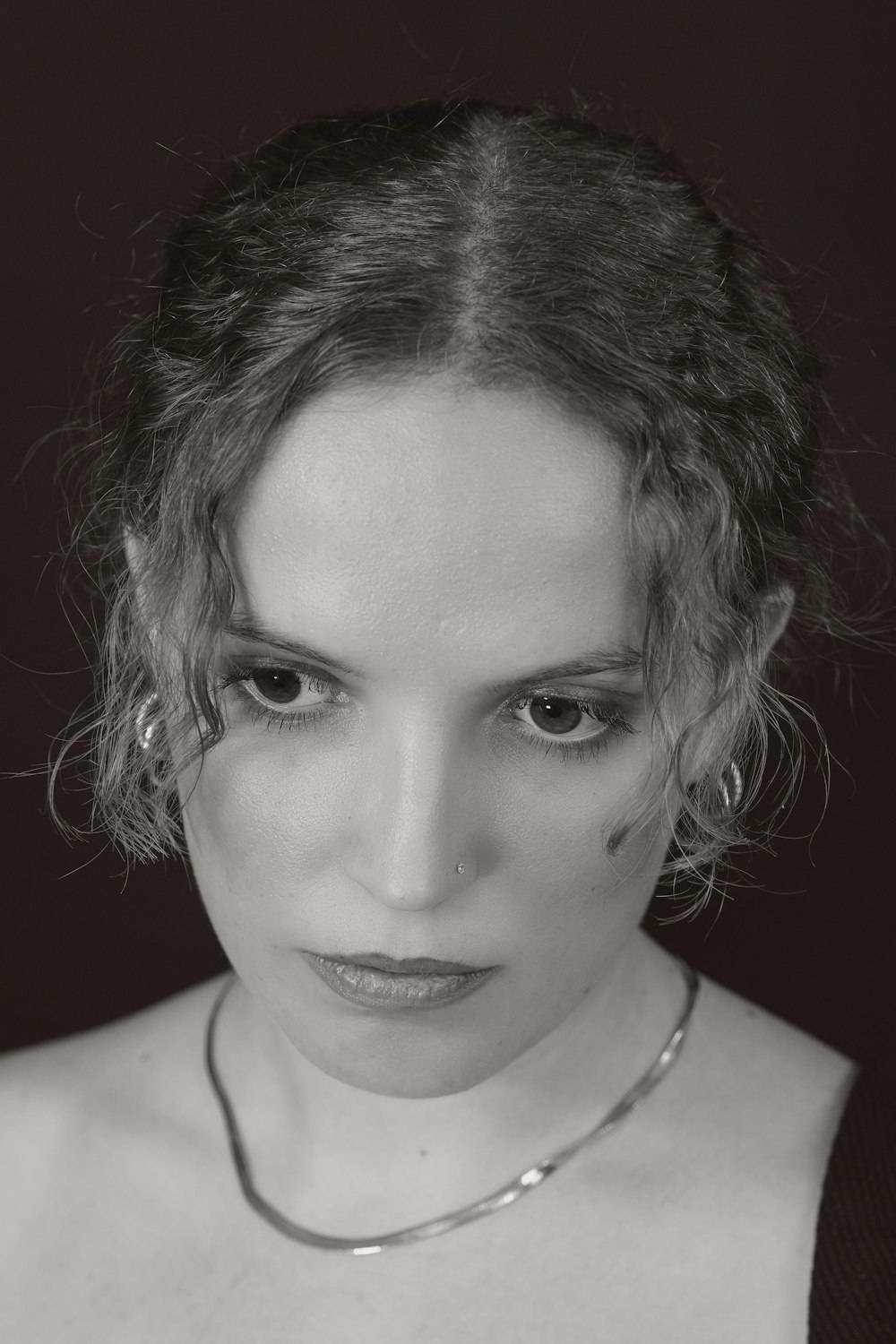 a black and white photo of a woman wearing a necklace