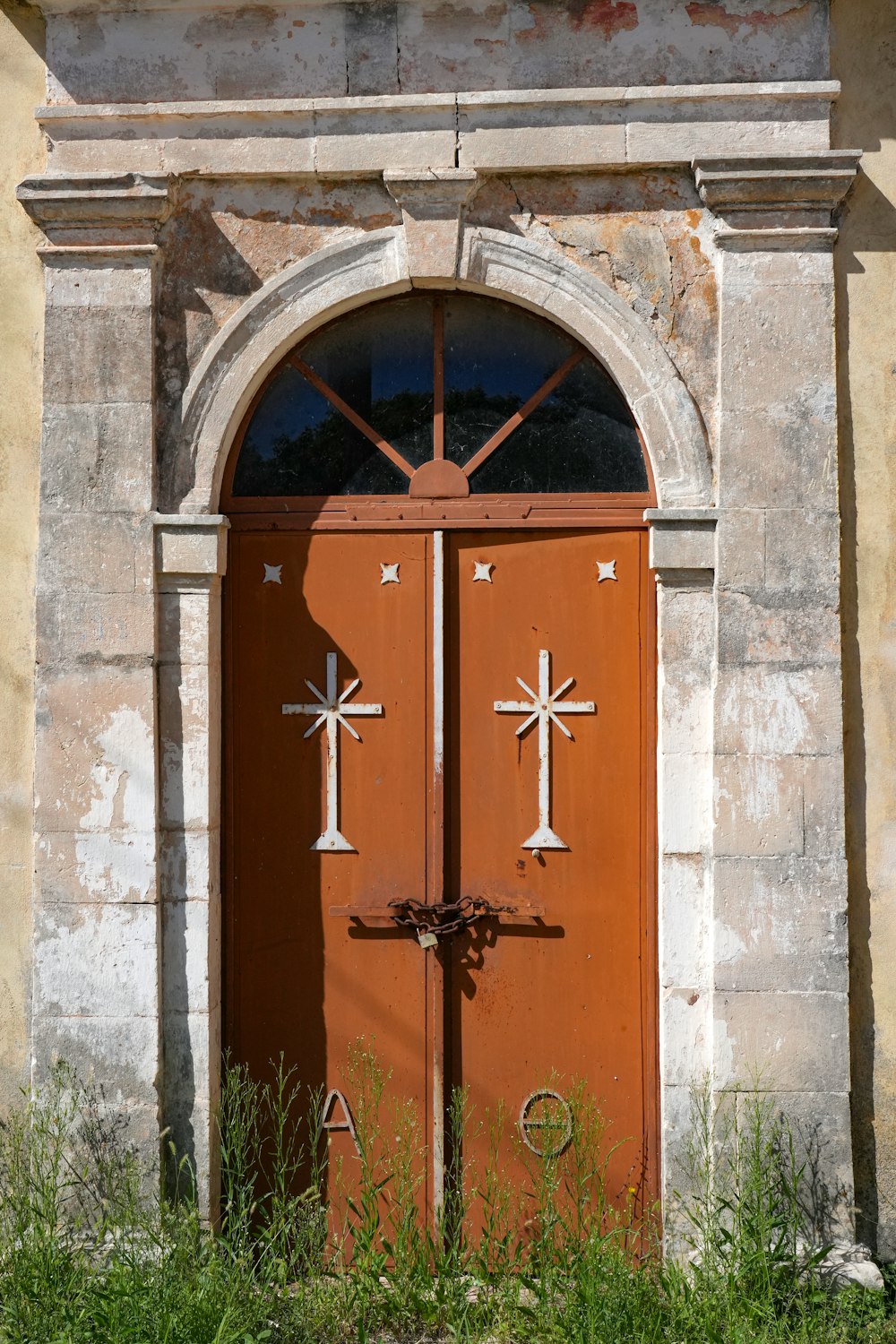 a red door with crosses on it in front of a building