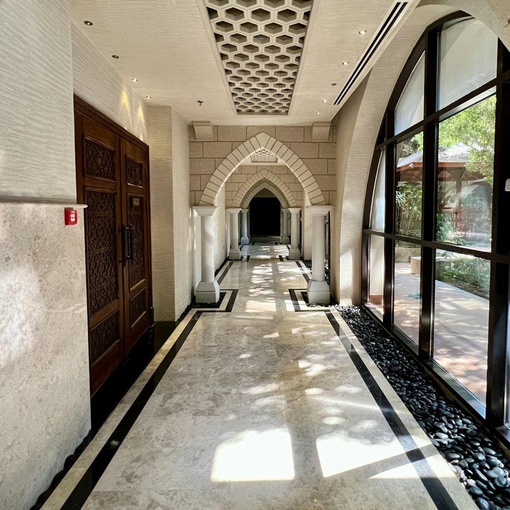 a long hallway with large windows and a door