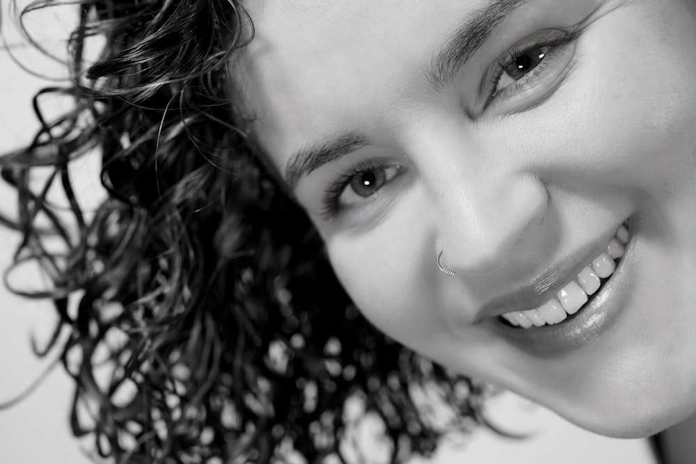 a black and white photo of a smiling woman