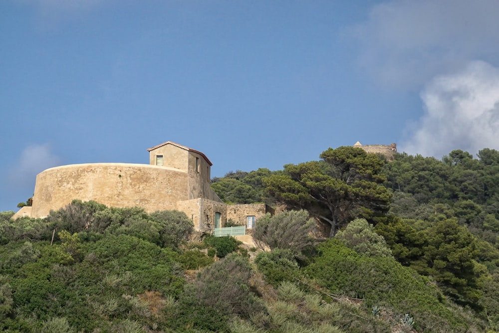 a building on top of a hill surrounded by trees