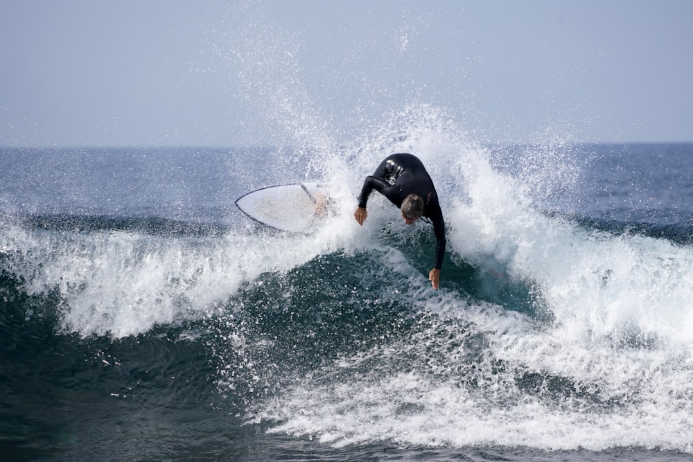 a man riding a wave on top of a surfboard