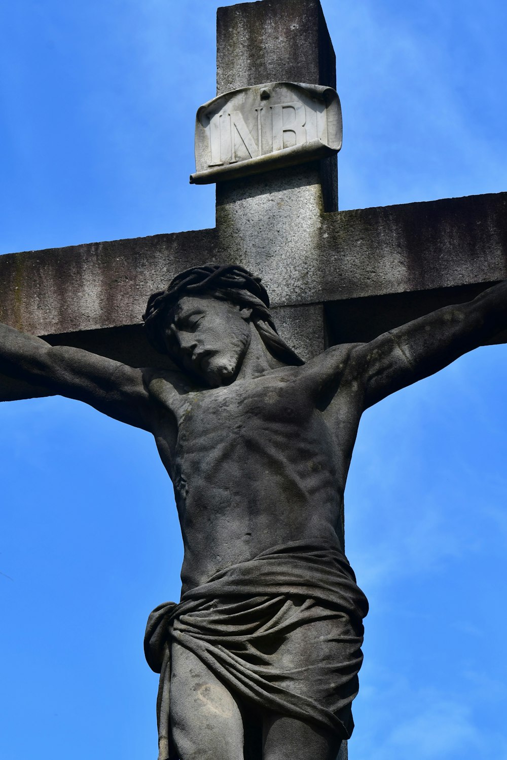 a statue of jesus on a cross with a sky background