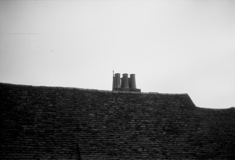 a black and white photo of chimneys on a roof