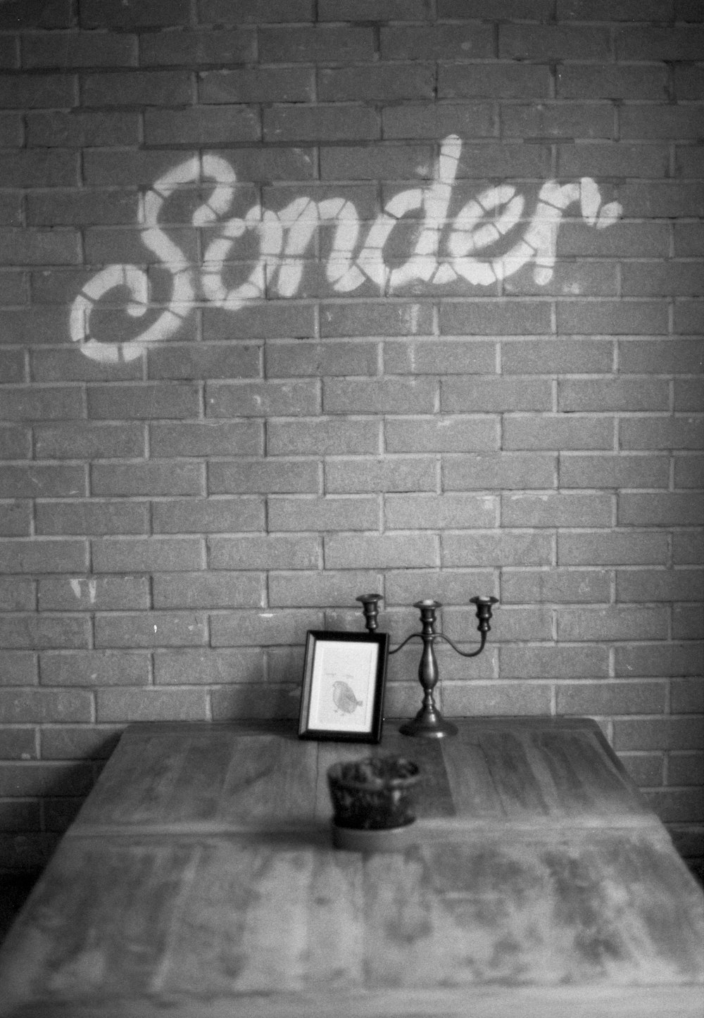 a wooden table sitting in front of a brick wall