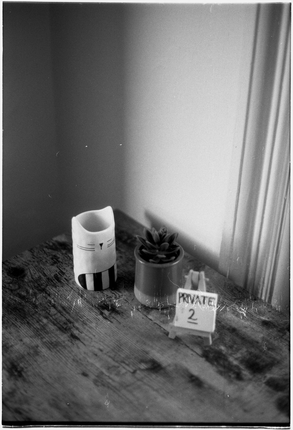 a wooden table topped with a potted plant next to a sign