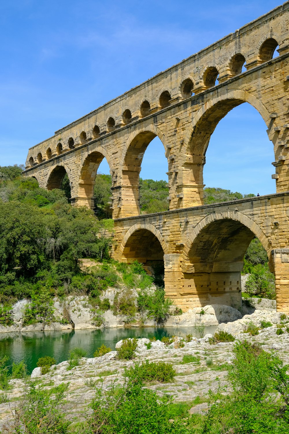 a stone bridge over a river surrounded by trees