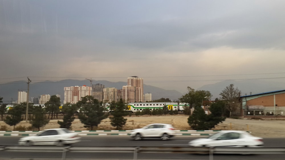 Coches que circulan por una autopista con una ciudad de fondo