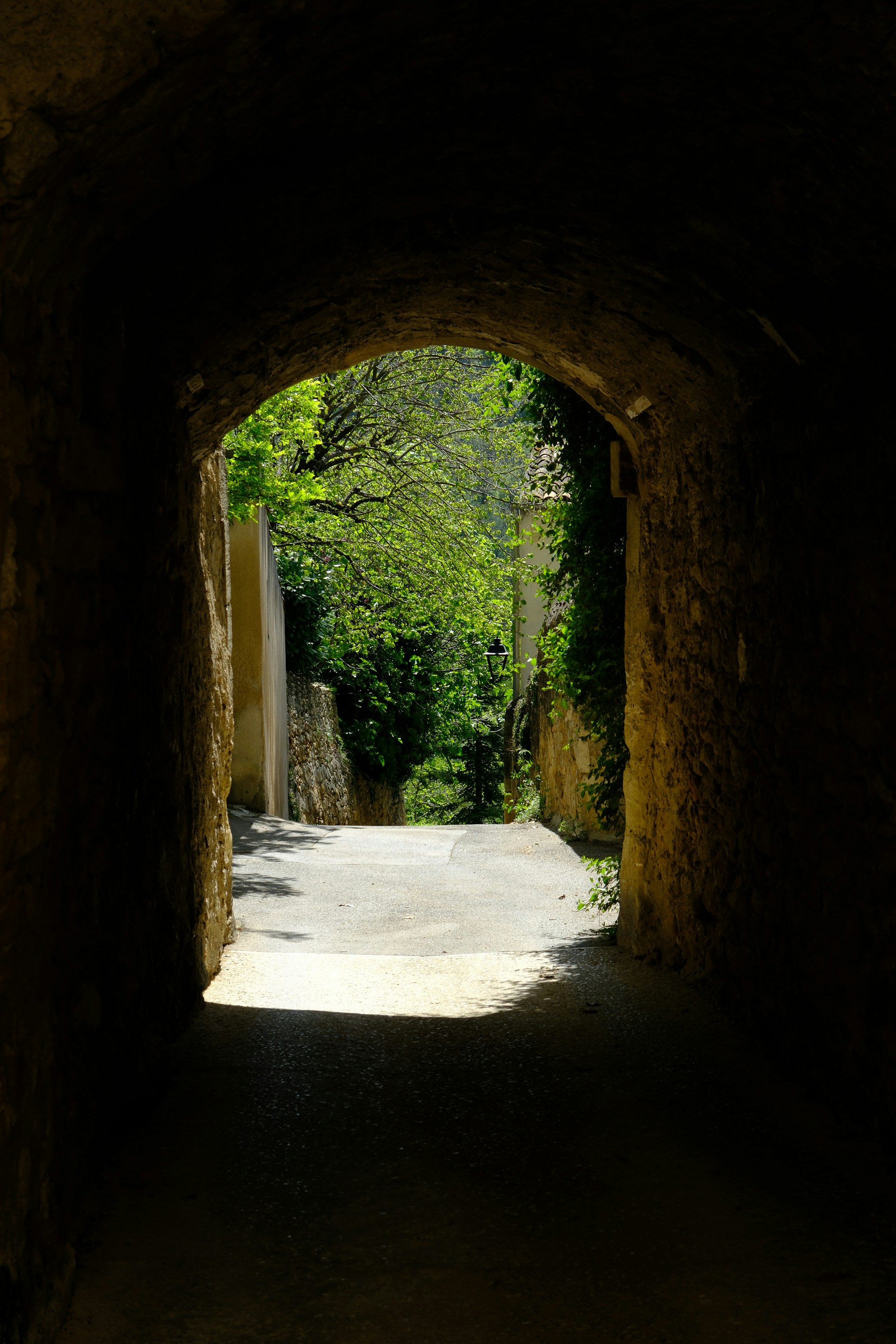 a tunnel in a stone wall with a light at the end