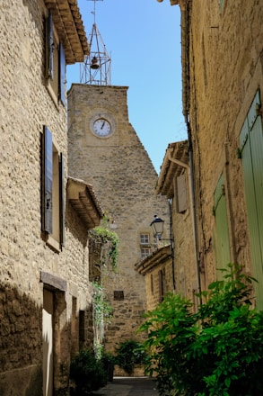 a clock on the side of a stone building