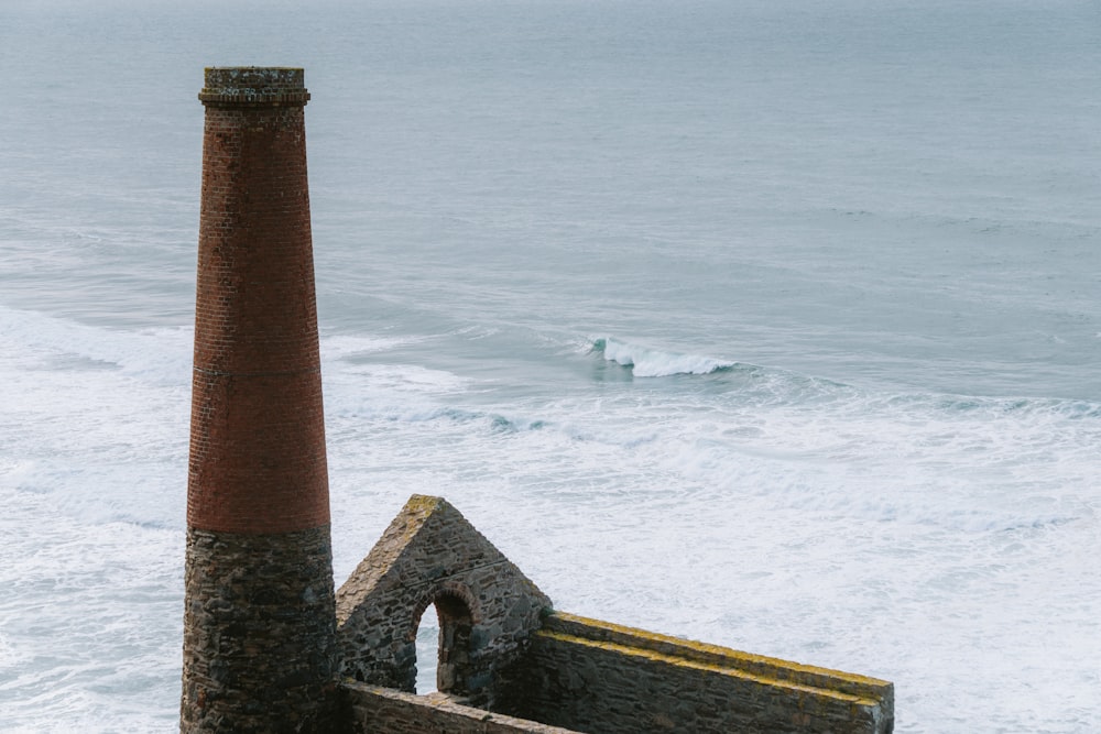 a view of the ocean with a brick chimney in the foreground