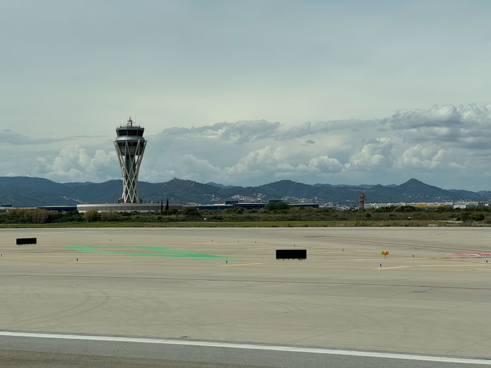 an airport runway with a control tower in the background