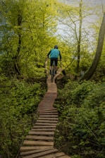a man riding a bike down a wooden path