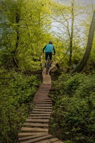 a man riding a bike down a wooden path