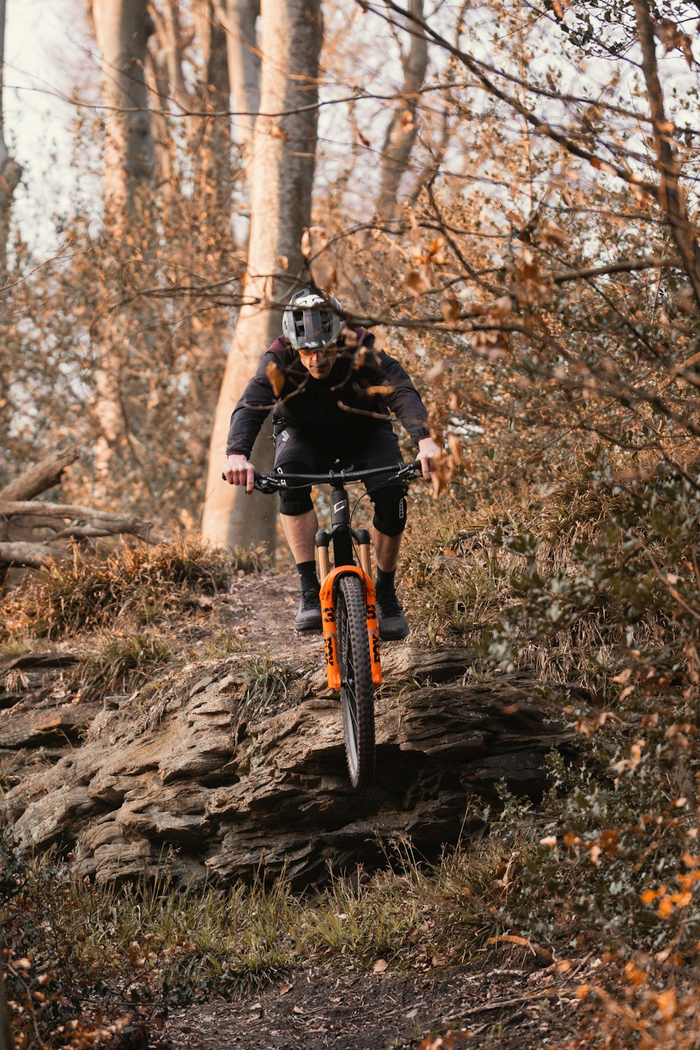 a person riding a bike on a trail in the woods