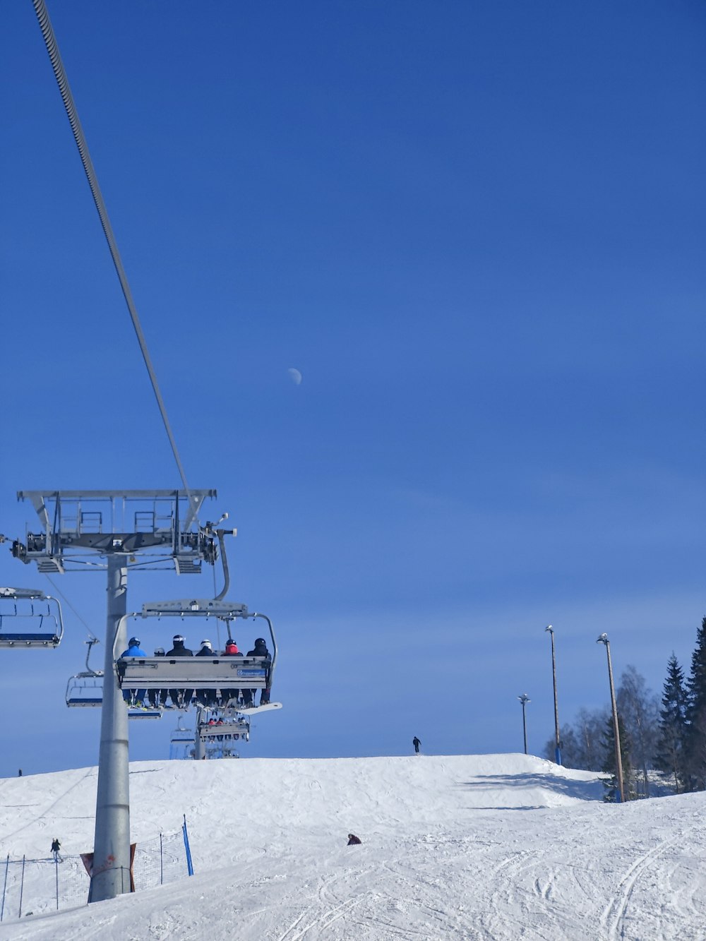 a ski lift going up a snowy hill