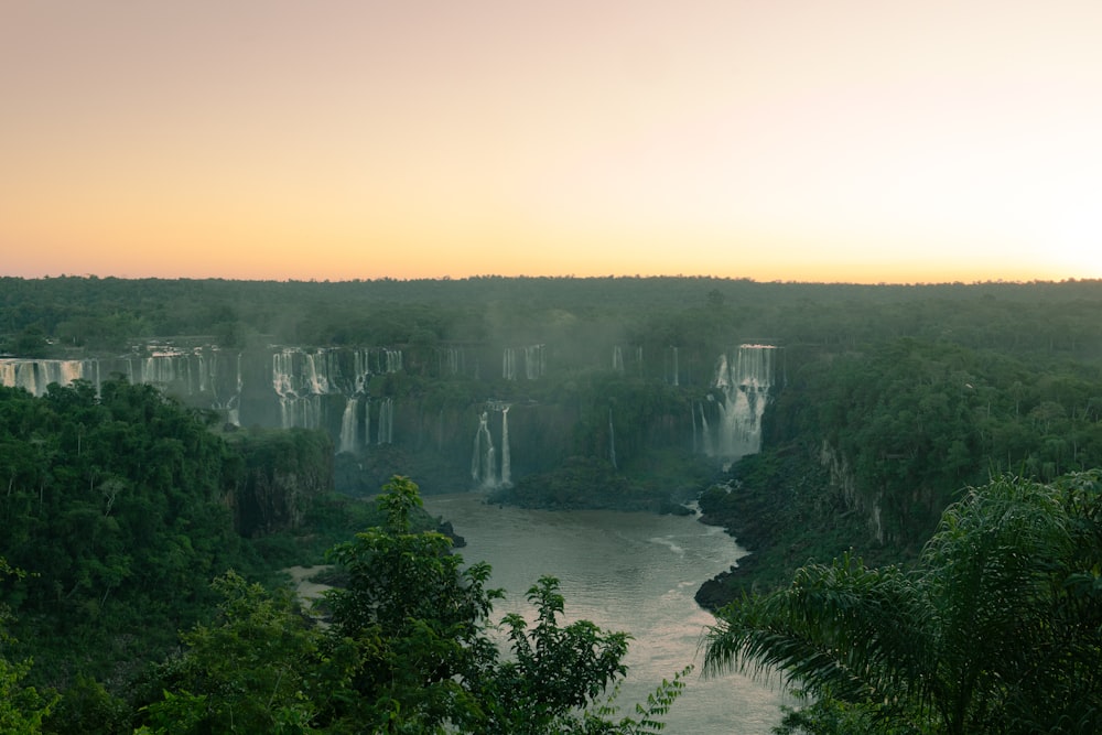 a large waterfall in the middle of a forest