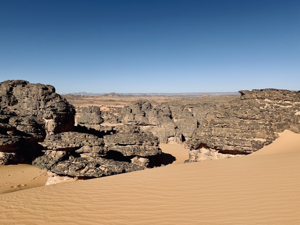 a desert landscape with rocks and sand in the foreground