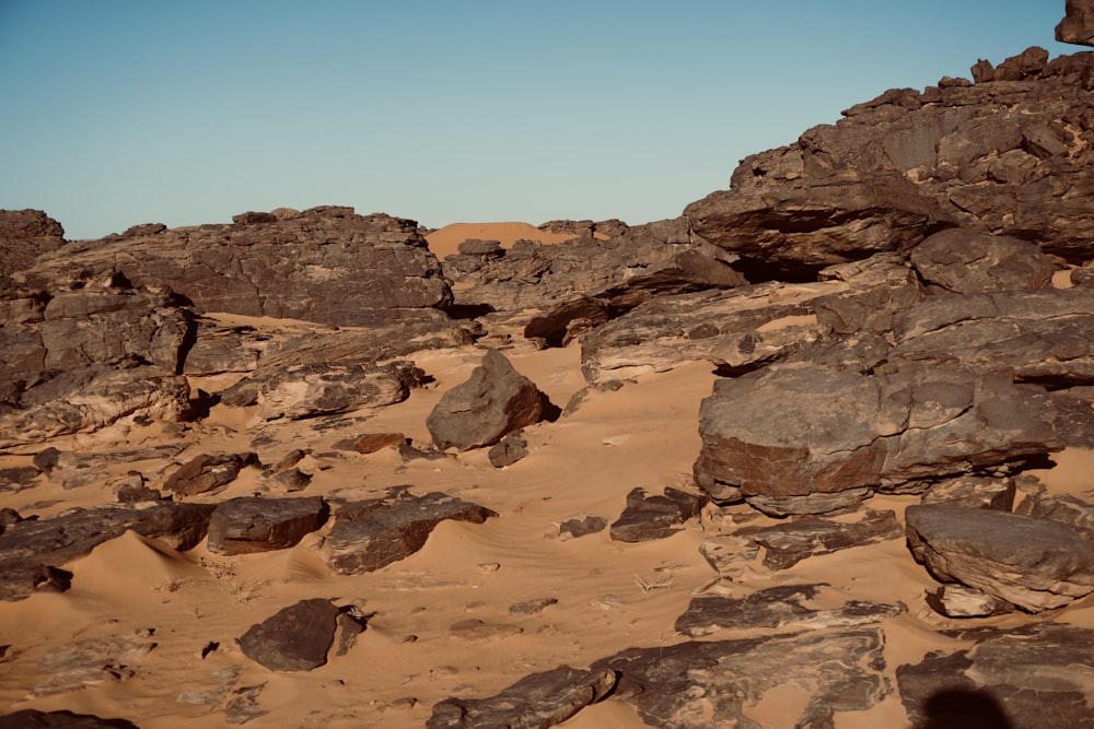 rocks and sand in the desert under a blue sky