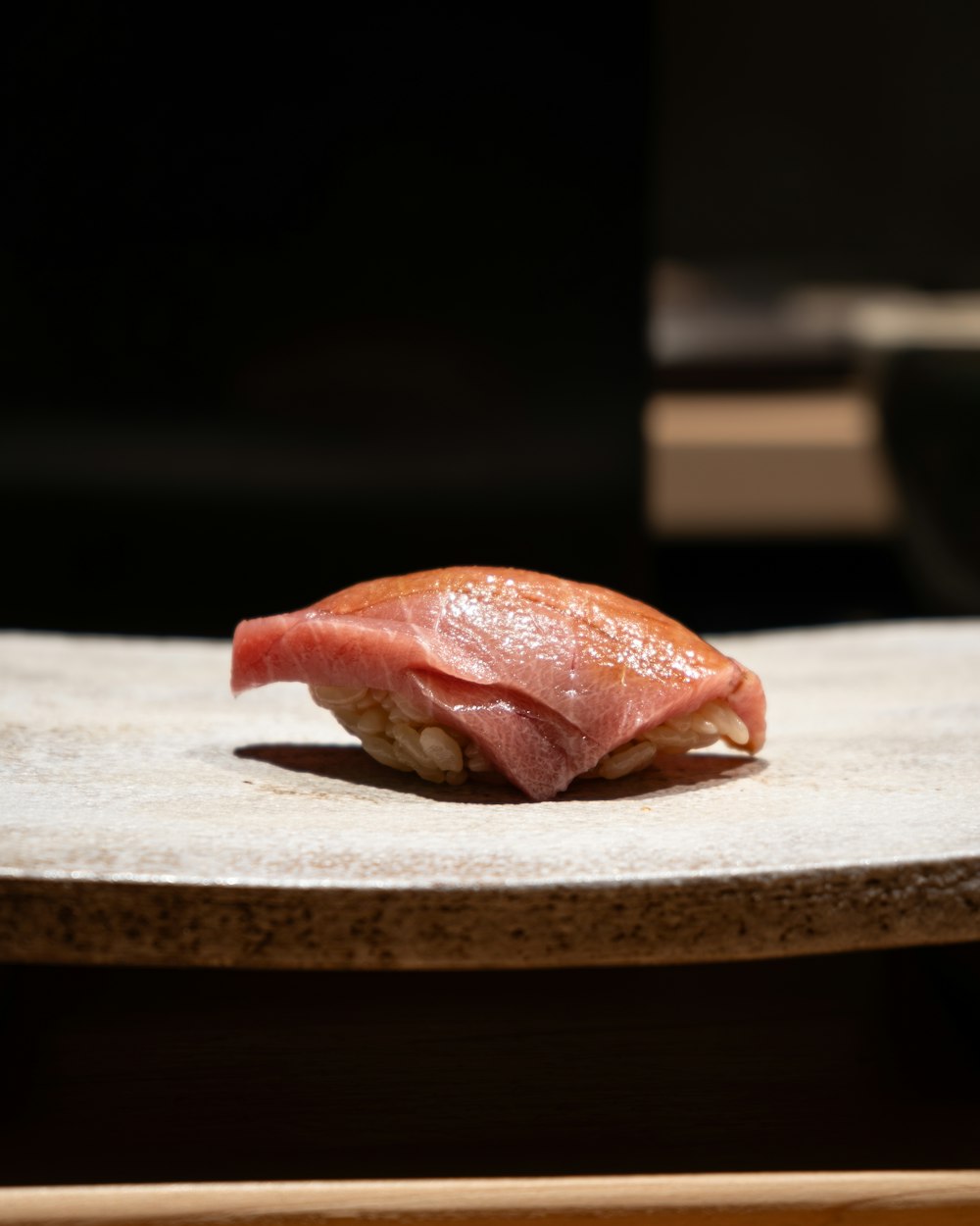 a piece of sushi sitting on top of a wooden table