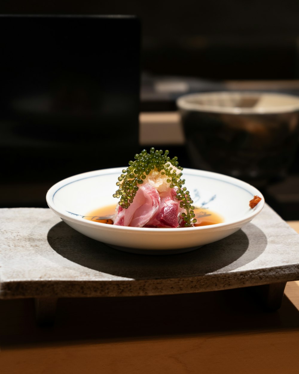 a plate of food on a table with a laptop in the background