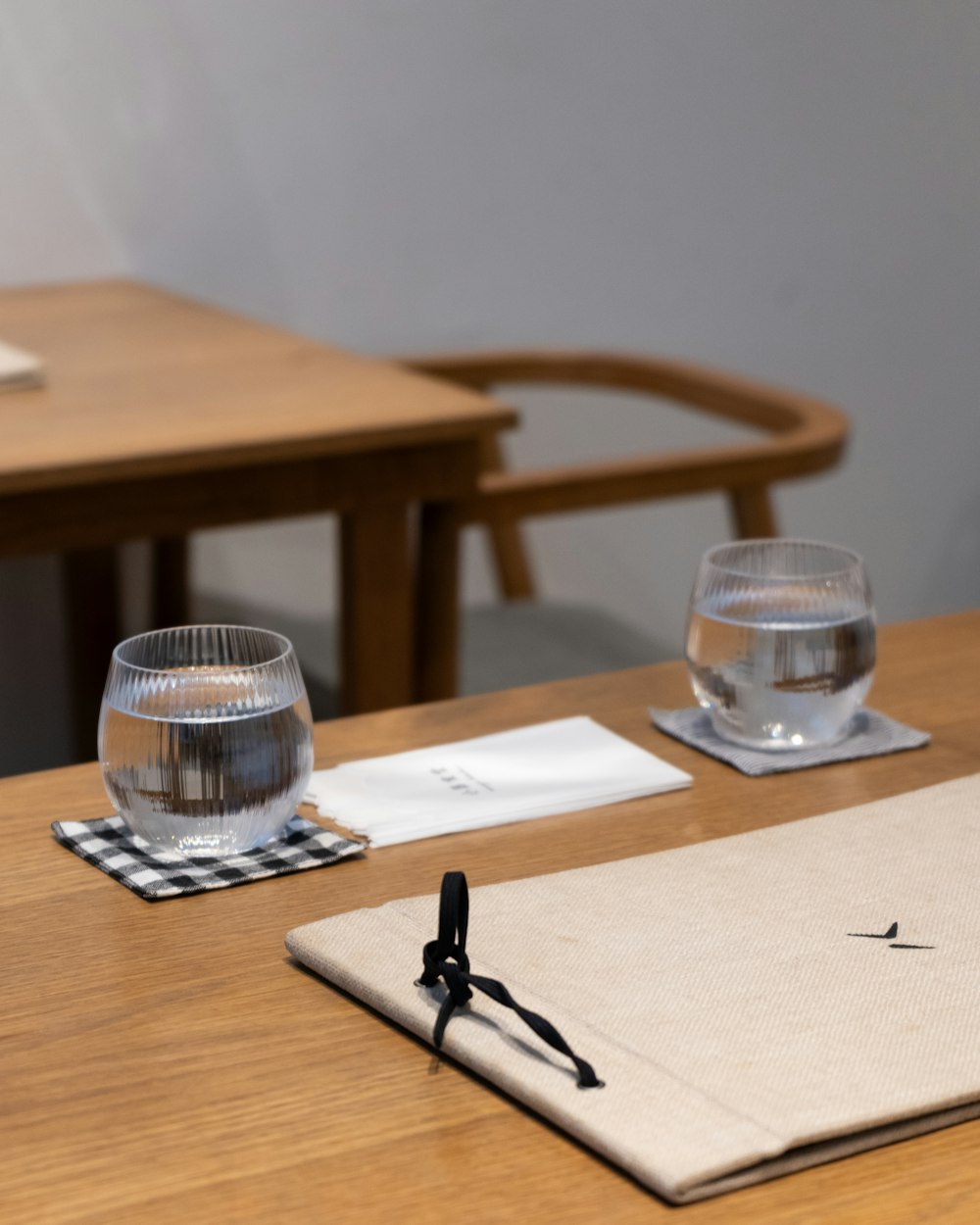 a wooden table topped with two glasses of water