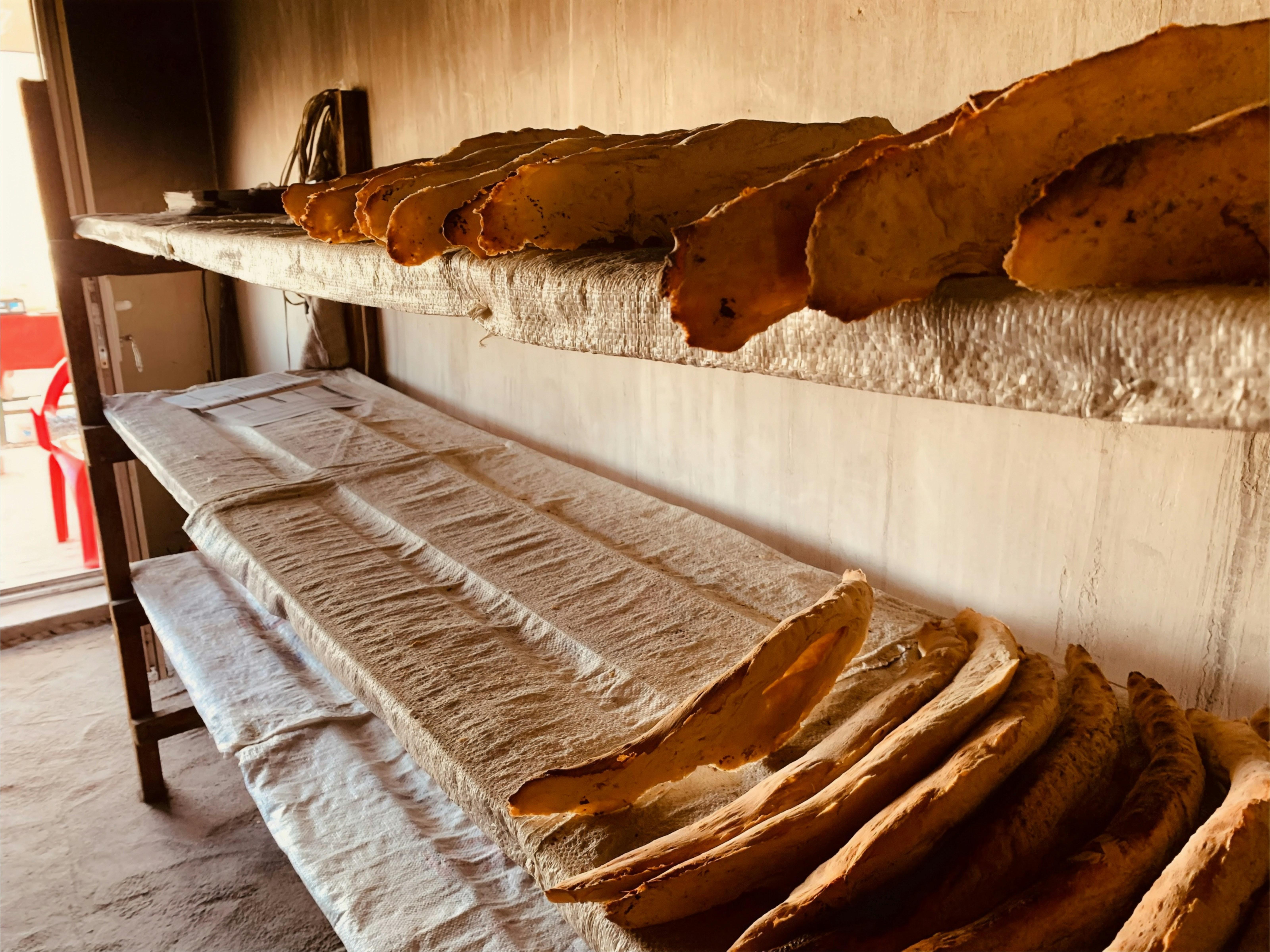 Warm inviting bakery interior with wooden shelves and fresh baked loaves