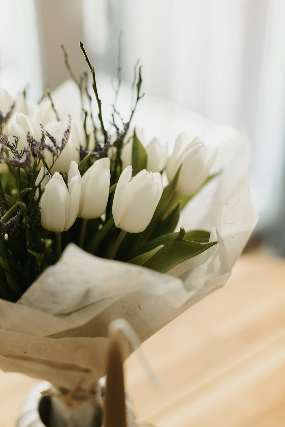 a bouquet of white tulips on a table