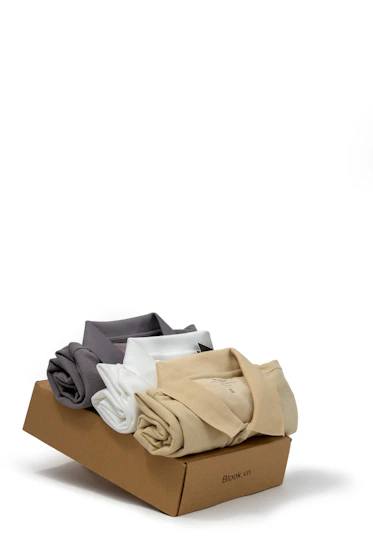 a box of folded clothes on a white background