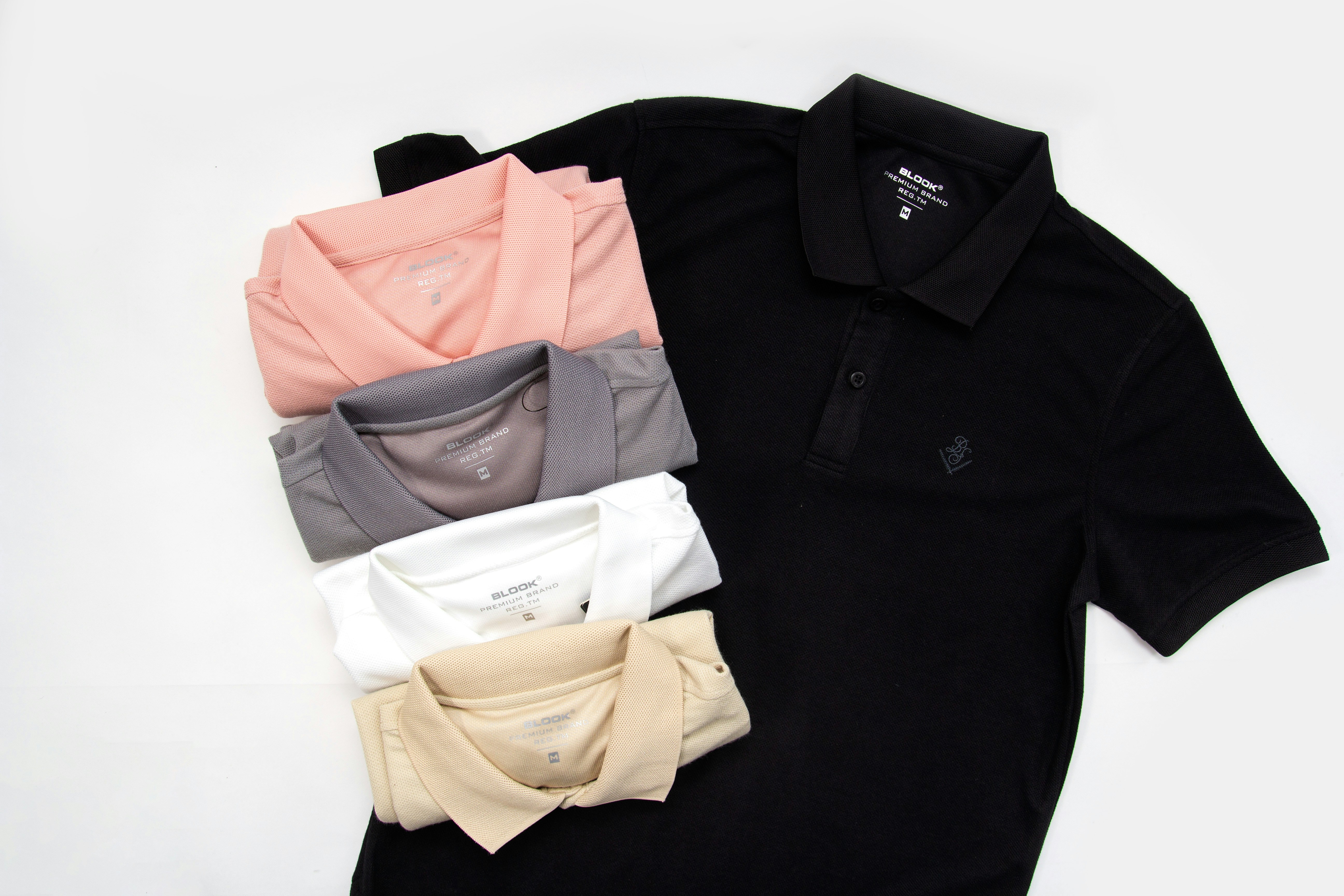 a group of polo shirts sitting on top of a white table