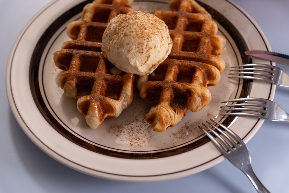 a plate of waffles with a scoop of ice cream on top
