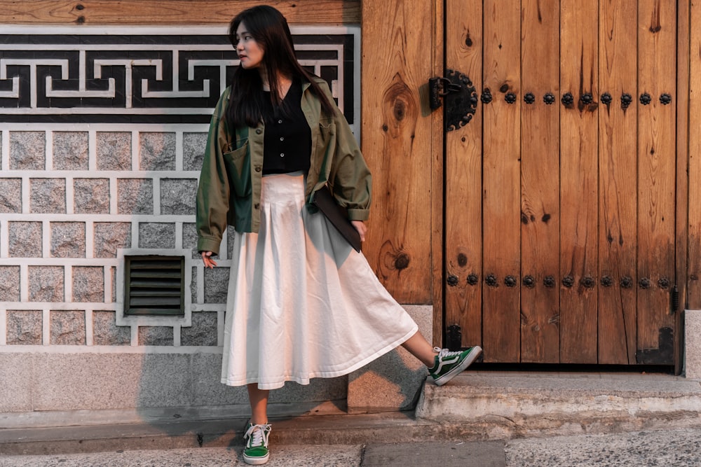 a woman standing in front of a wooden door