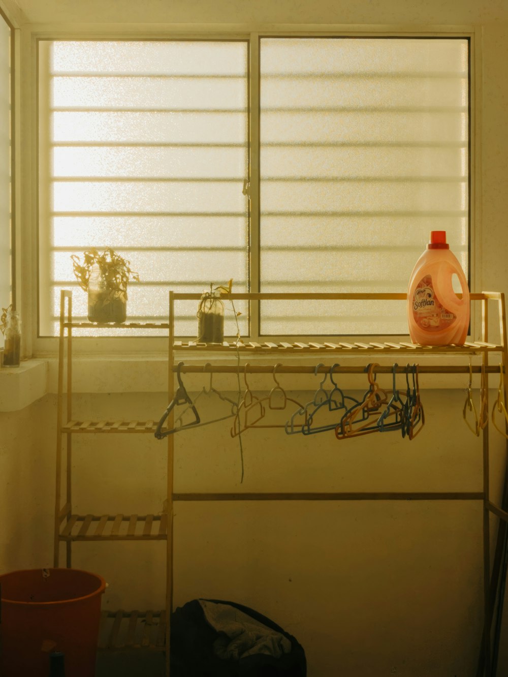 a room with a window and a shelf with a vase on it